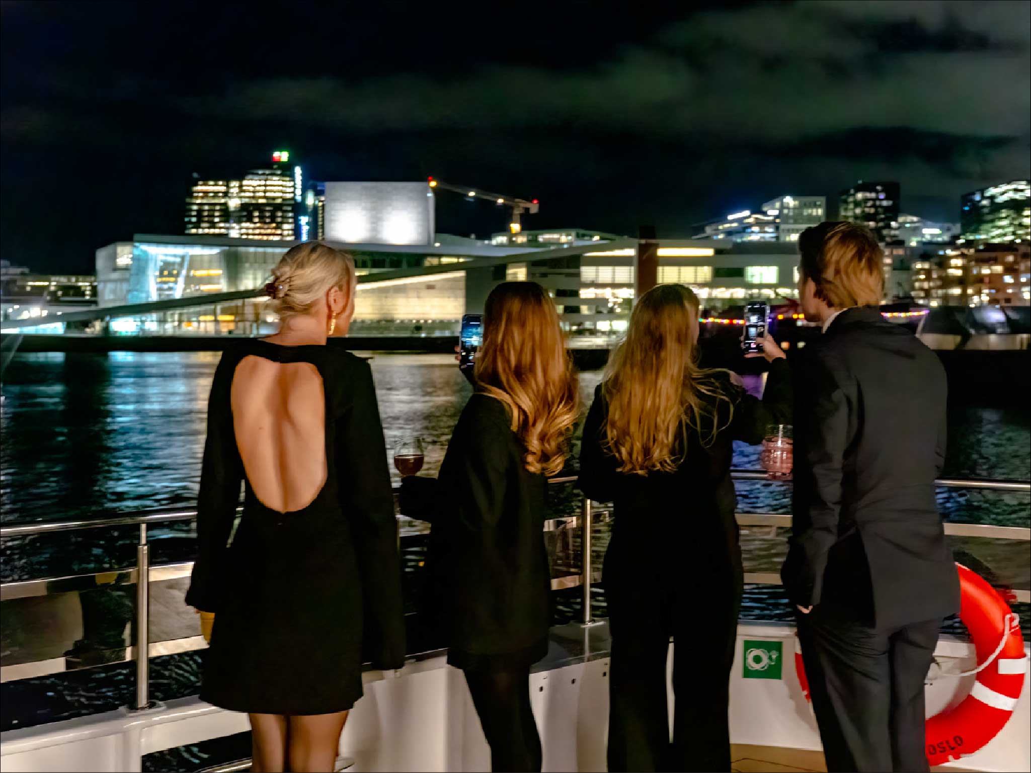 Gjester på båtdekk med operahus i bakgrunnen