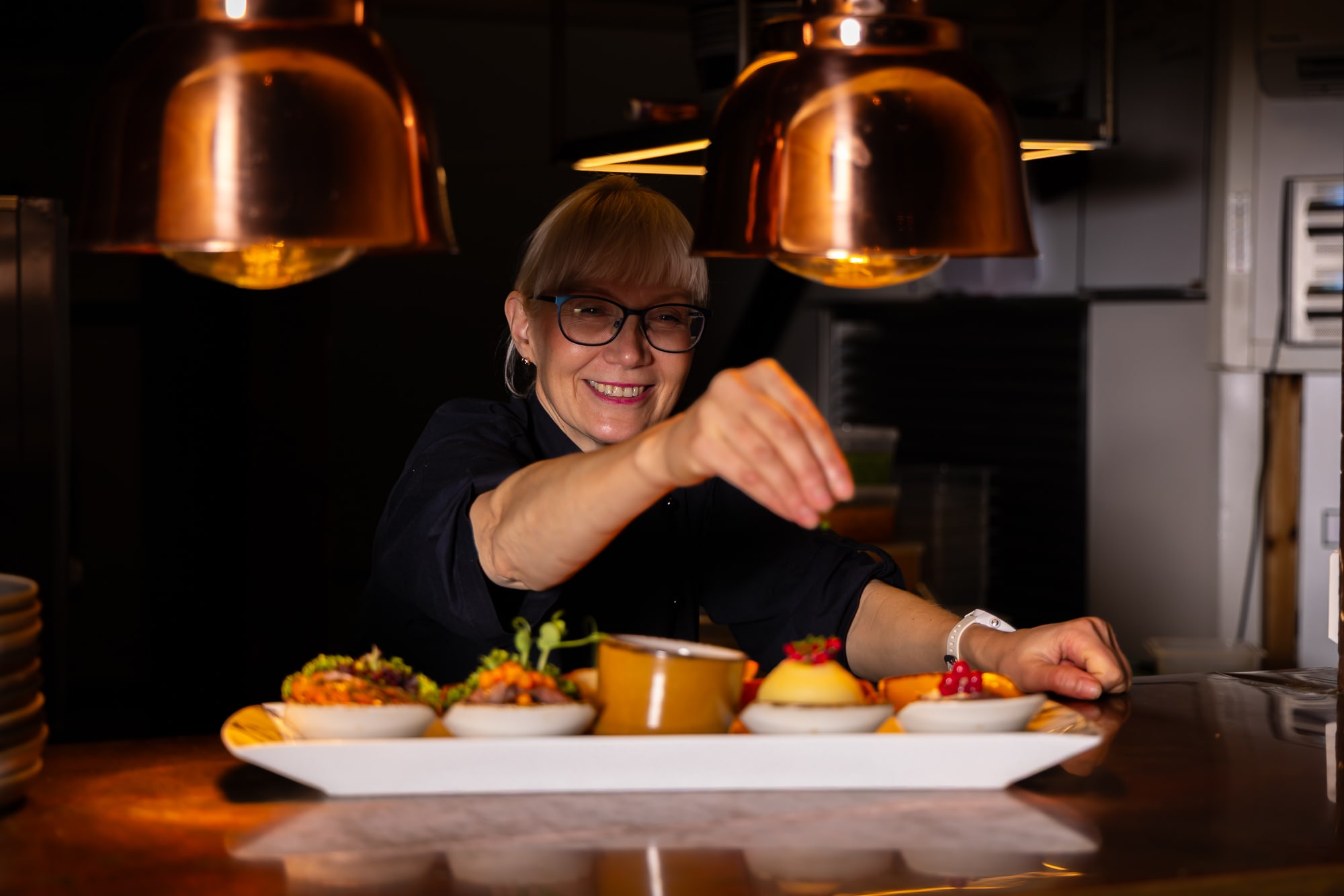 Chef preparing Viking plank with local Norwegian ingredients at Ægir Brewery in Flåm for 5-course dinner and beer tasting