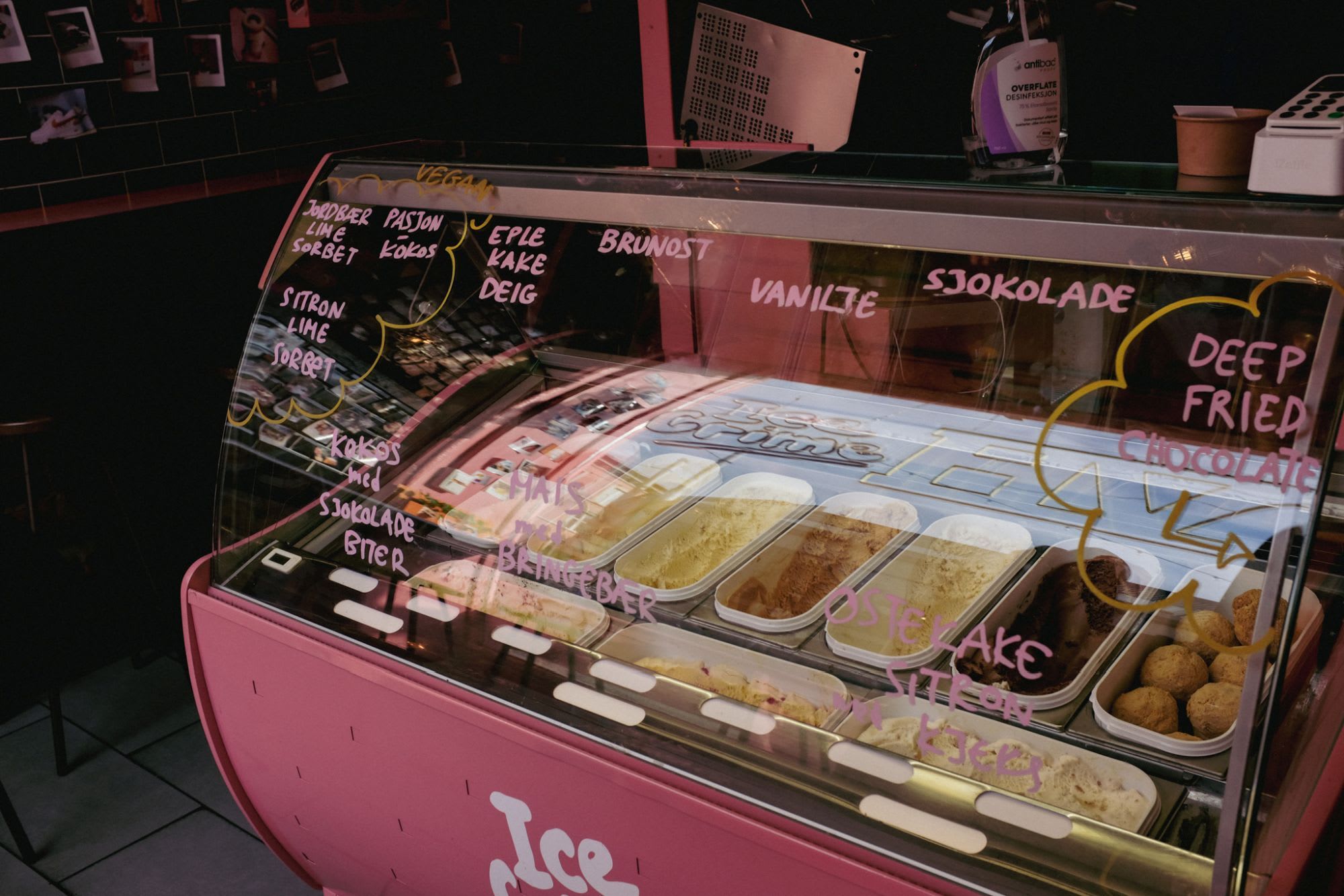 Bunter Eistresen mit Töpfen, die mit verspielten Beschriftungen versehen sind, was eine einladende, künstlerische Shop-Atmosphäre schafft.