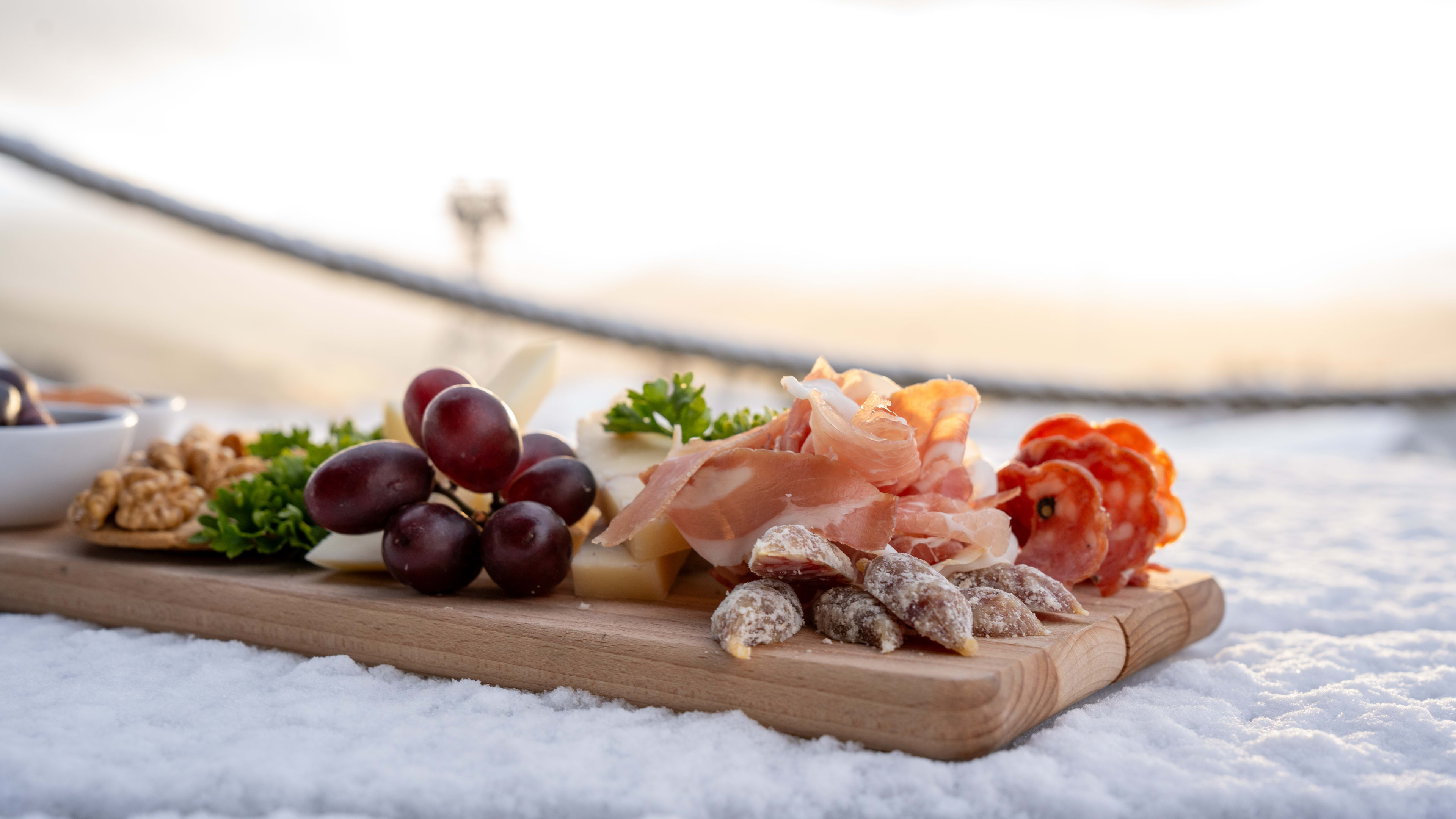 Traditional Norwegian charcuterie board featuring local cured meats, artisan cheeses, fresh grapes and sausages served at Hanguren Restaurant in Voss