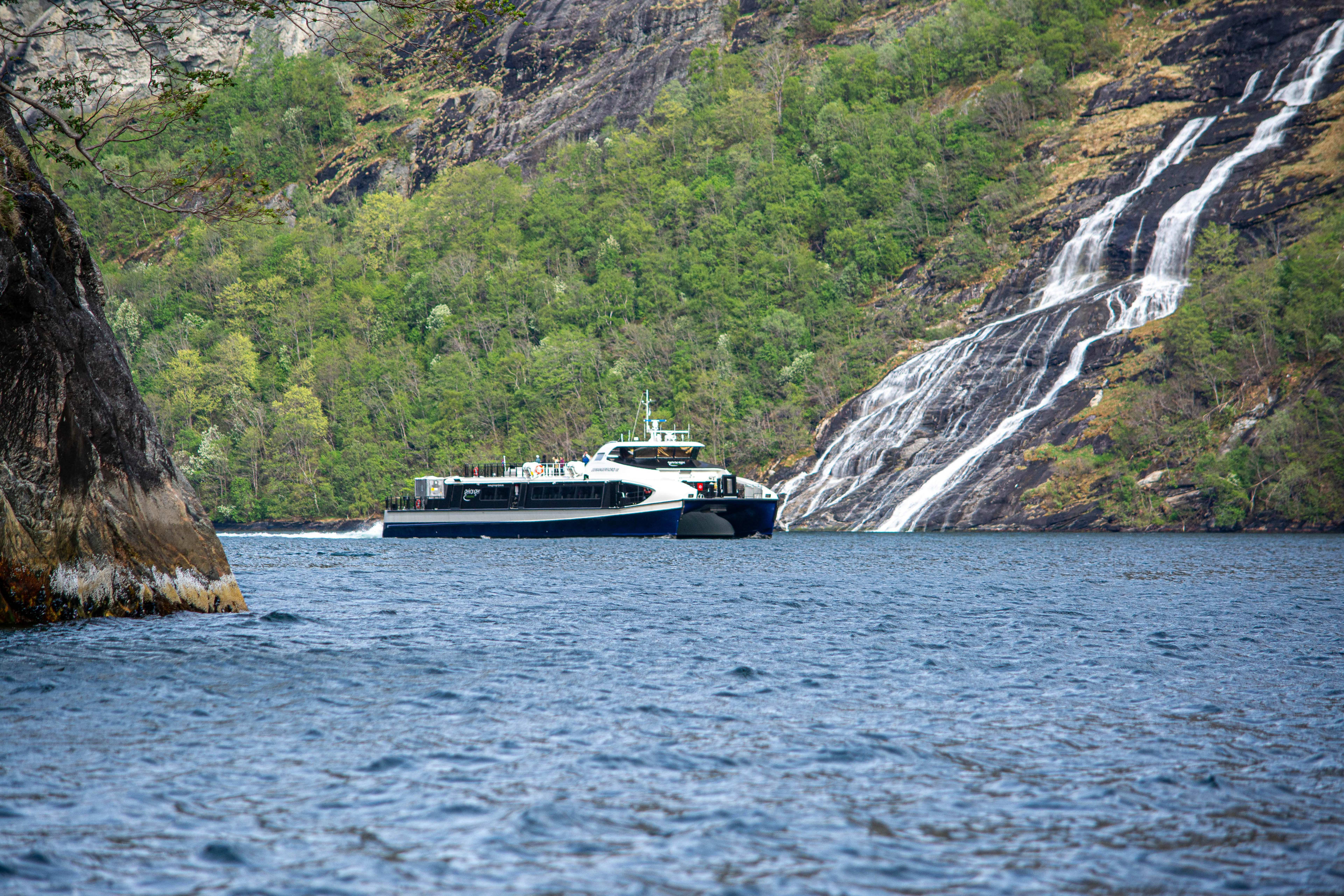 Electric boat tour on Geirangerfjord passing waterfalls – UNESCO World Heritage fjord, Norway