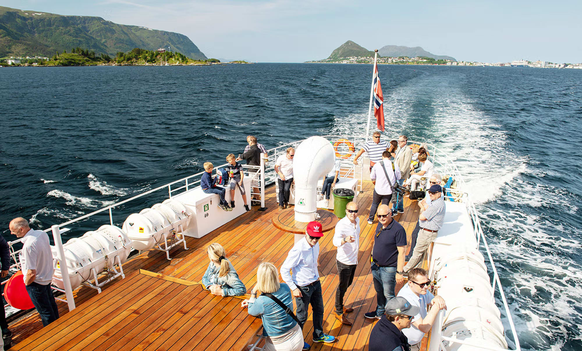 Passengers enjoying deck experience on Norwegian fjord cruise