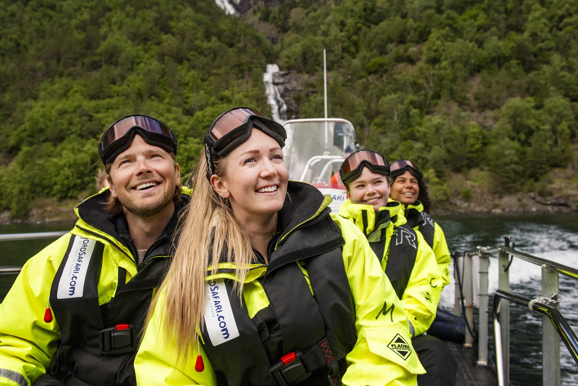 Couple enjoying fjord safari to Sagofossen waterfall in Flåm UNESCO landscape on summer day