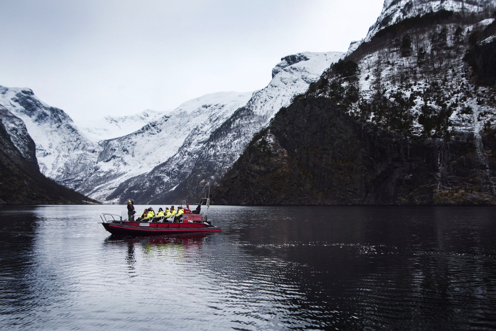 Vintersafari med ribbåt i Flåm på Nærøyfjorden, omgitt av klipper og snødekte fjell.