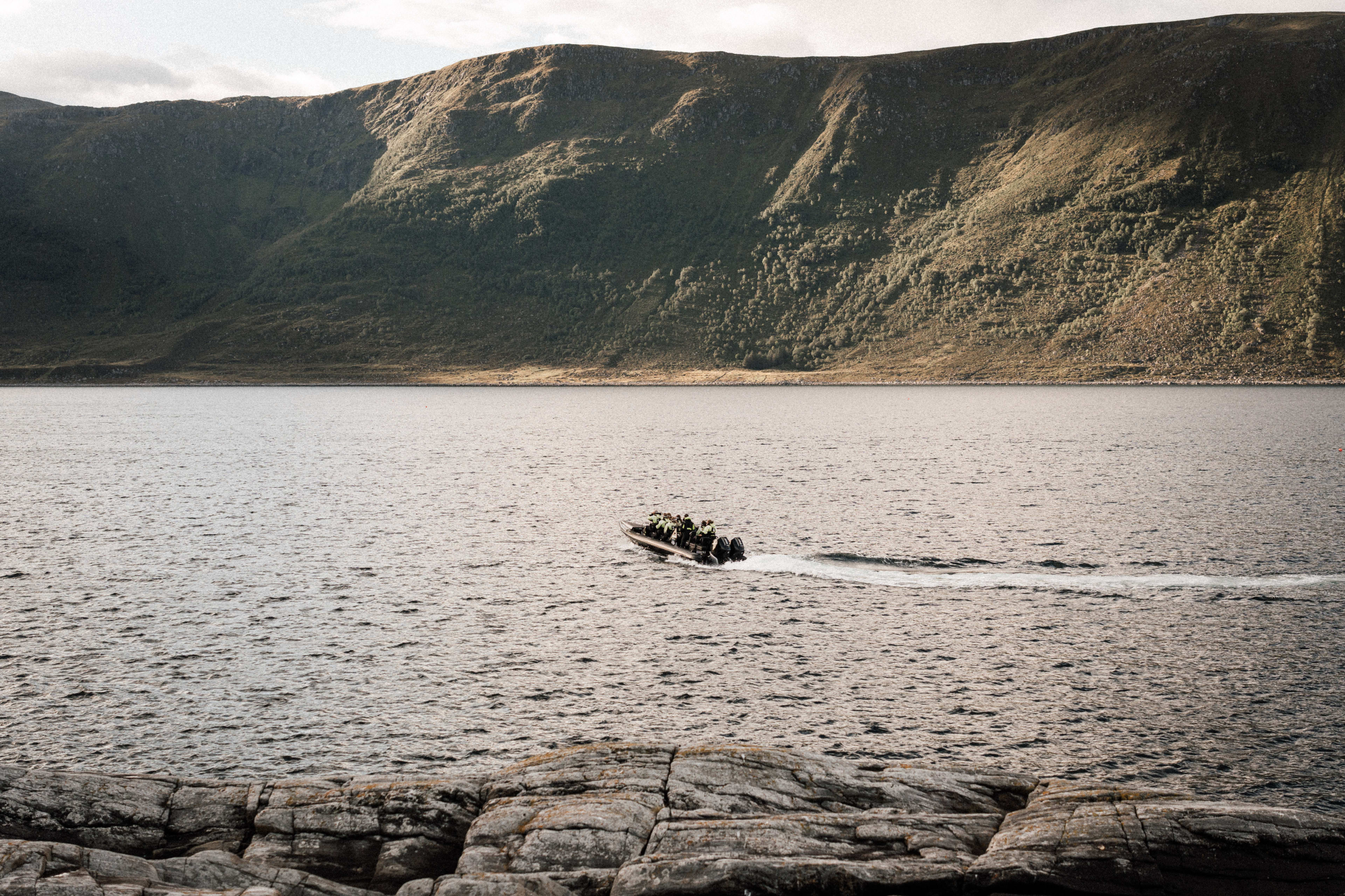 RIB boat tour along the rugged coast near Ålesund with passengers experiencing thrilling waves and dramatic coastal scenery