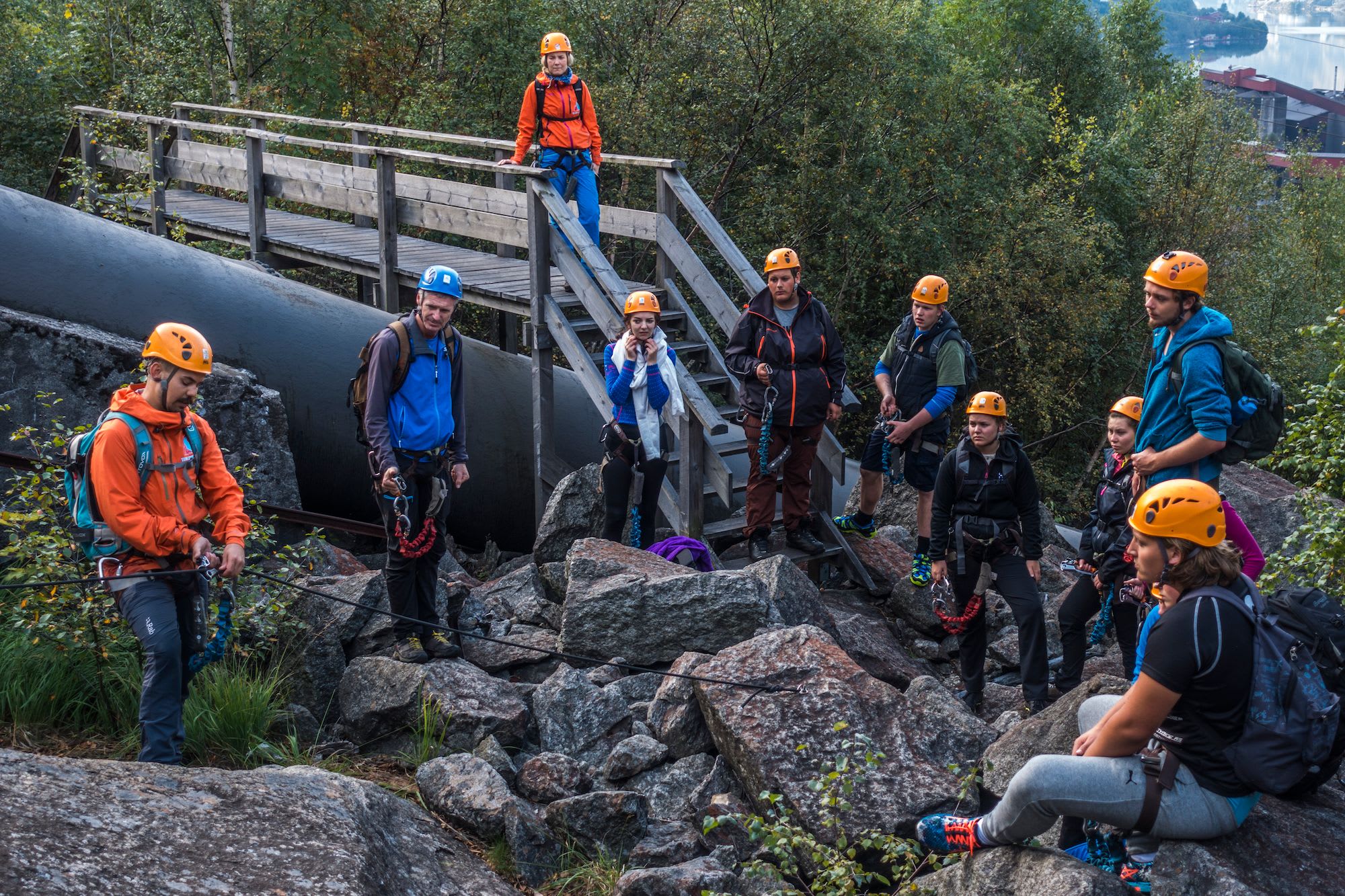Klatrere samles ved en bro for briefing før klatring.