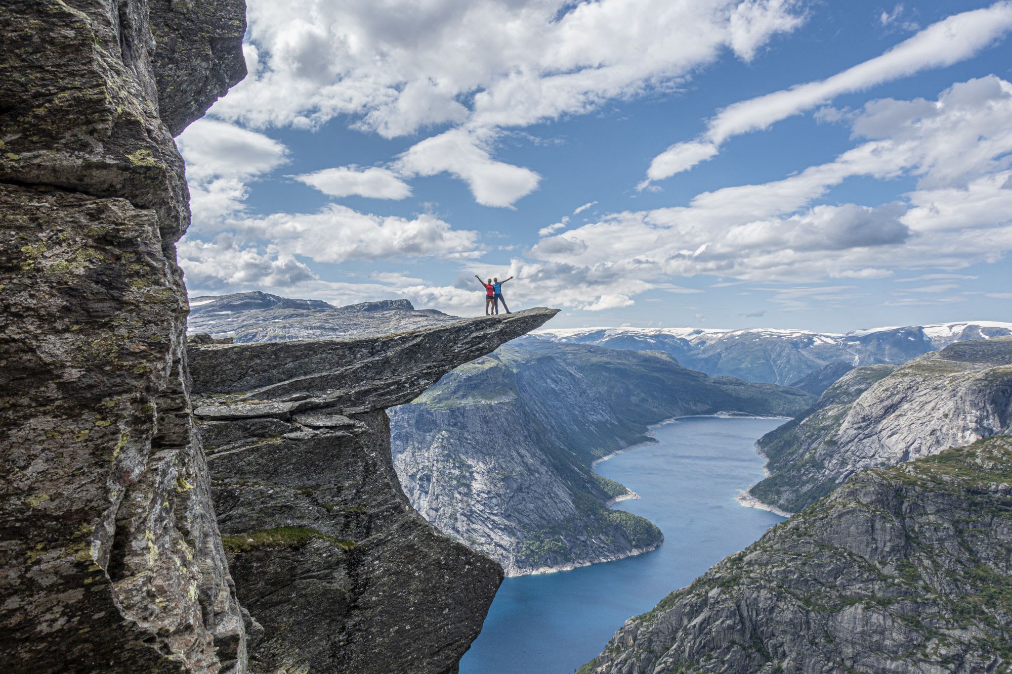 Happy hikers on Trolltunga after hiking the traditionelle route up to the top