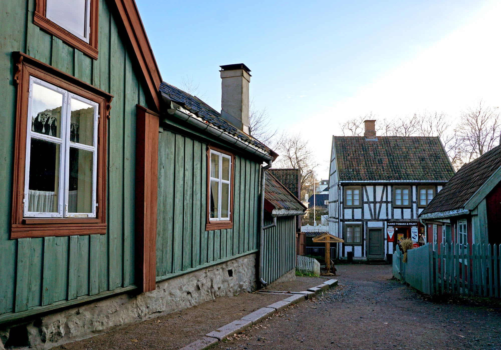 Charming village street with colorful wooden houses, white-trimmed windows, and half-timbered building.