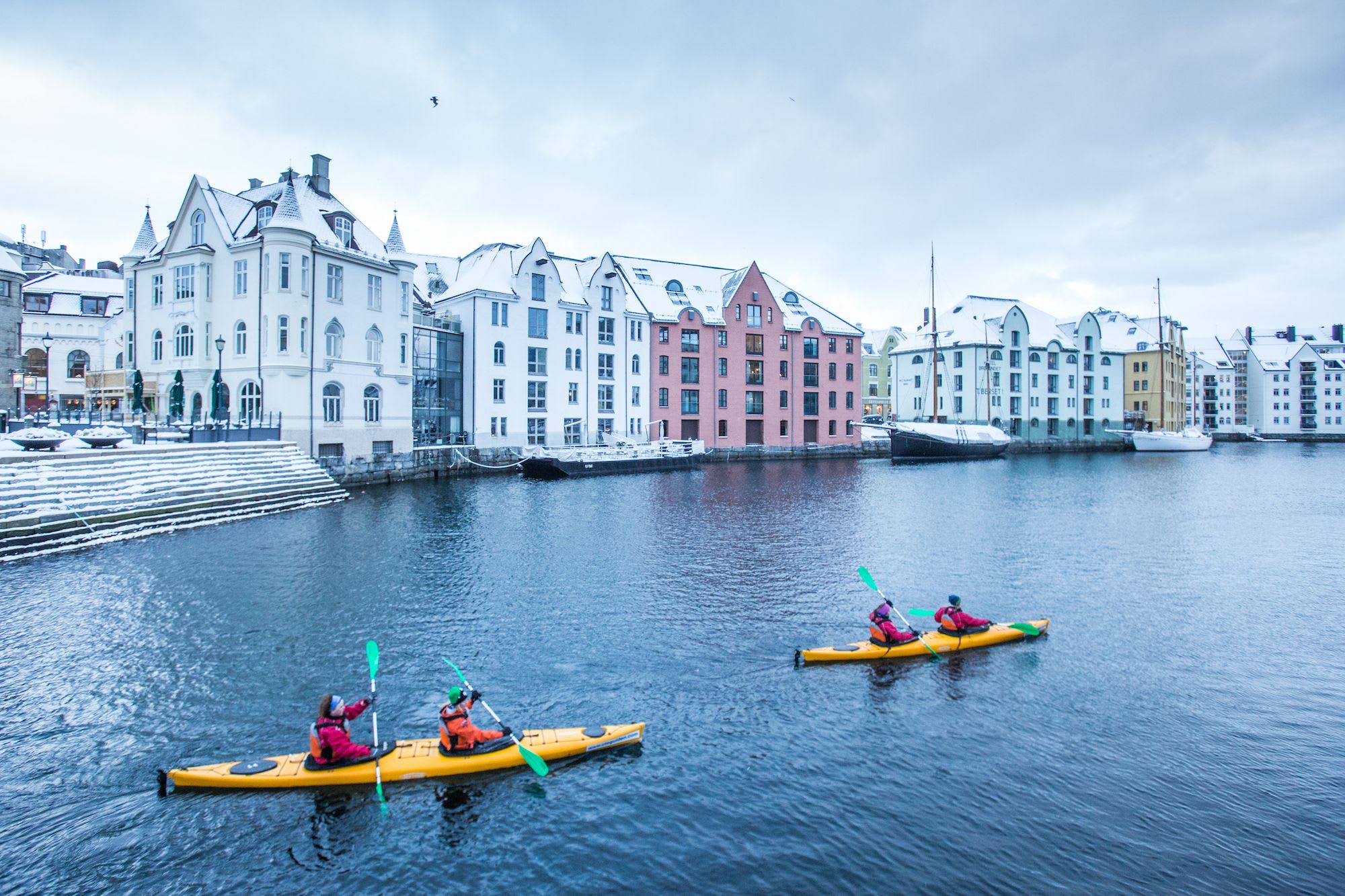 Kajakking i Brosundet sund omringet av Ålesund jugendstil-bygninger om vinteren