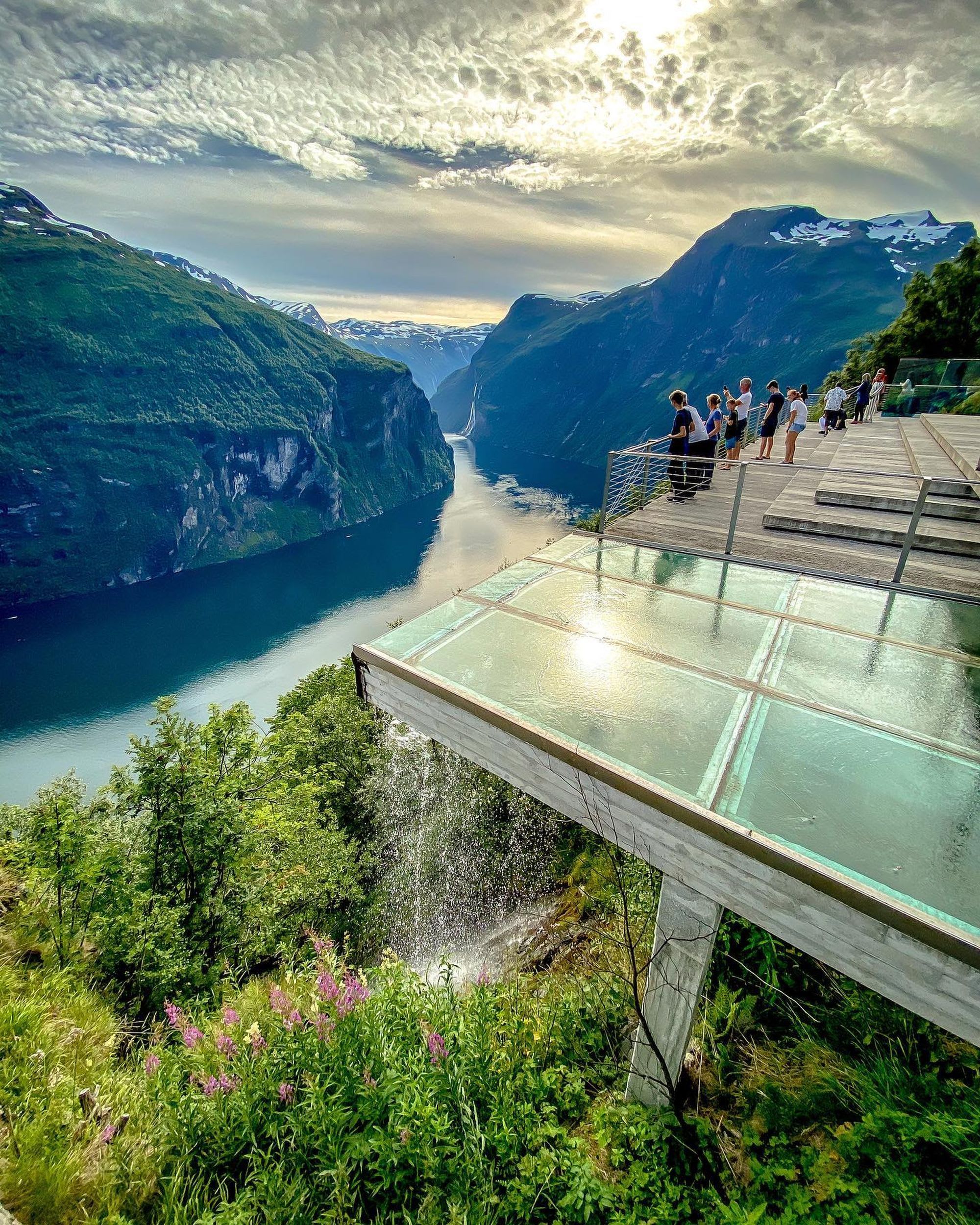 Tourists on Ørnesvingen viewing platform with stunning view of the Geirangerfjord.