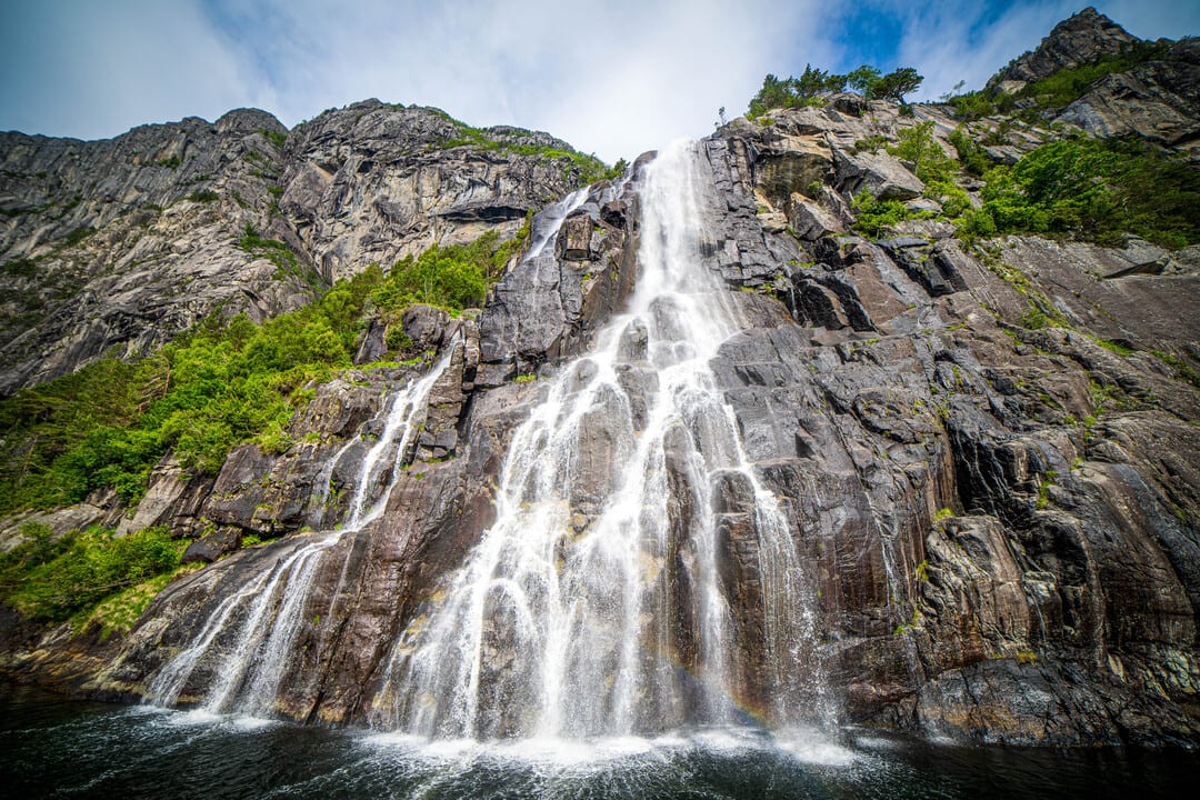 A waterfall cascading down the mountainside along the Lysebotn–Lauvvik ferry route.