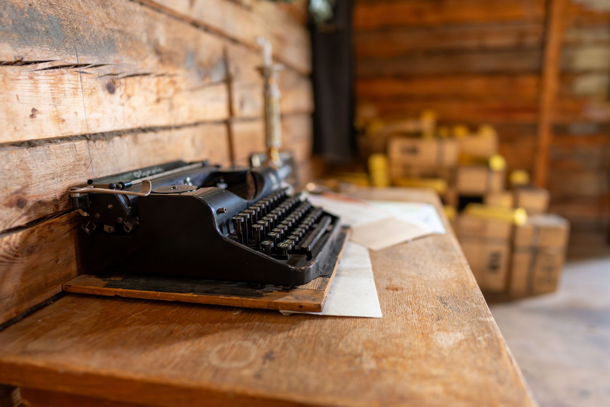 En gammel skrivemaskin på et trebord i et rustikt miljø, som vekker nostalgi med en vintage følelse.