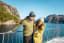 Smiling couple in enjoying the fjord cruise on the Lysefjord in winter, fjord and mountains behind.