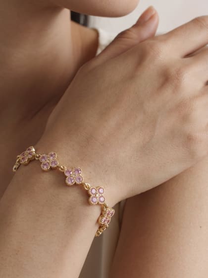 Poignet portant un bracelet à fleurs de zircons roses