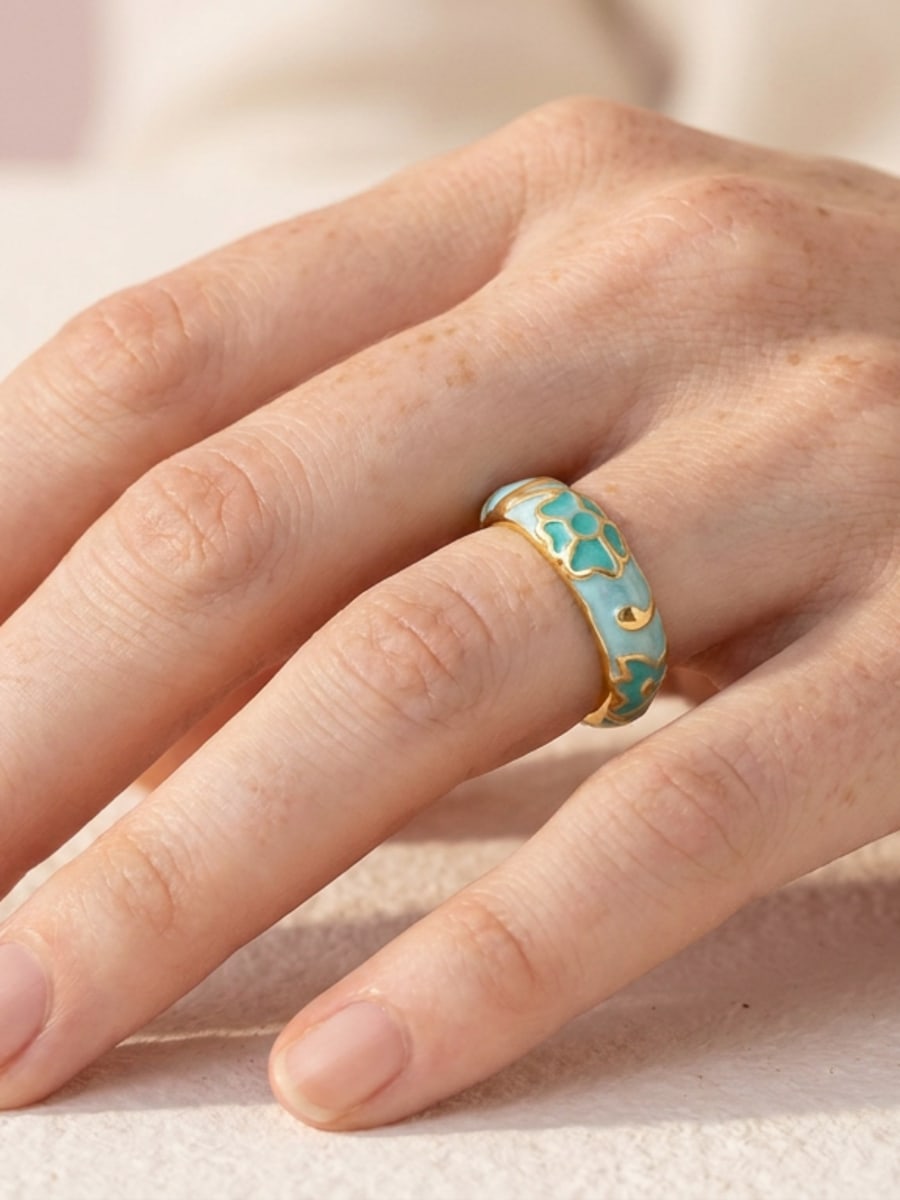 Main portant une bague émaillée