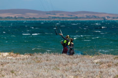 Walking at Aliki beach with student controlling the kite