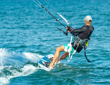 Kitesurf instructor taking the kite upwind for a student
