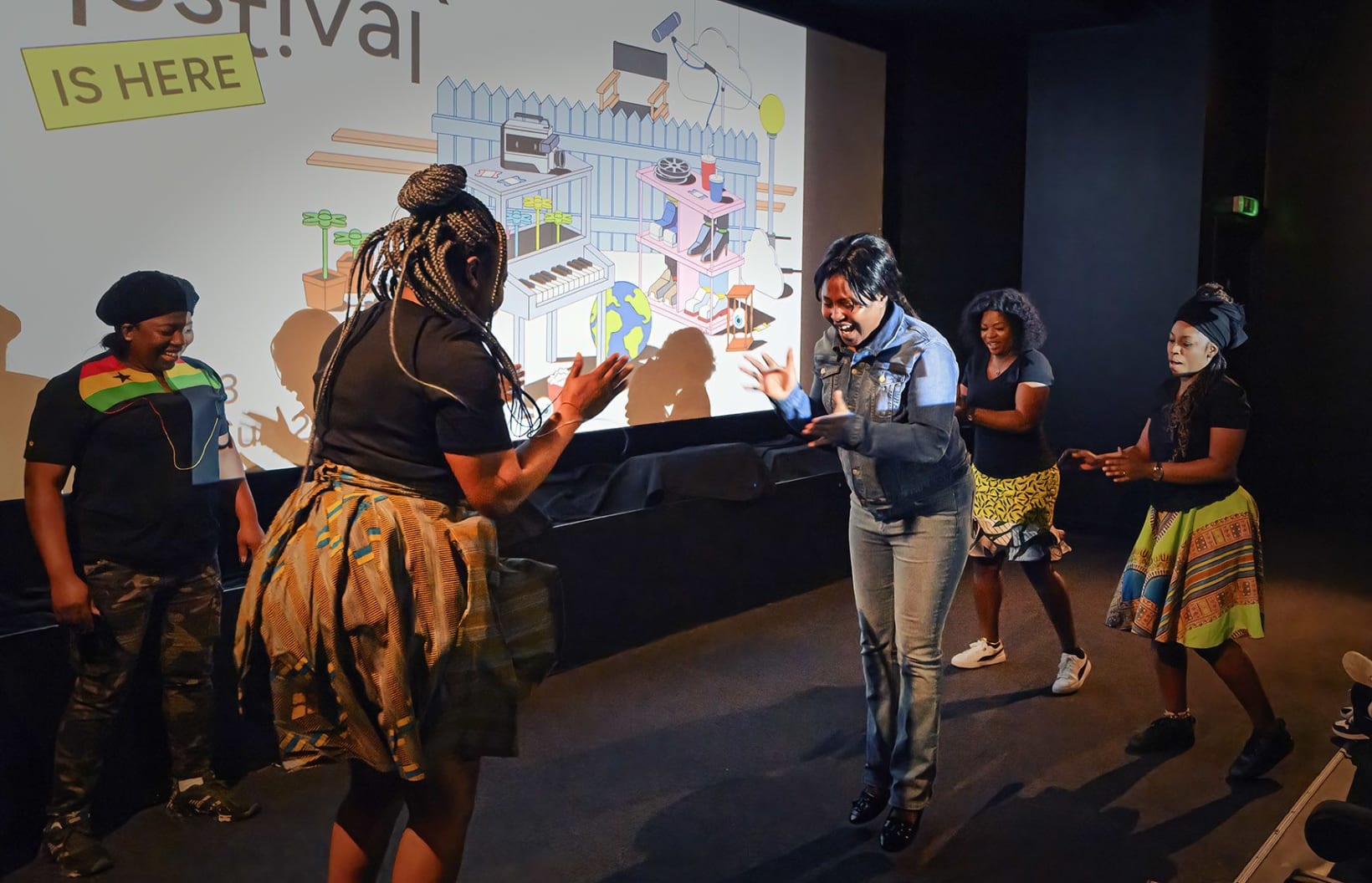 Five people playing the Ghanaian game Ampe, appearing almost as though dancing, energetically and joyfully.