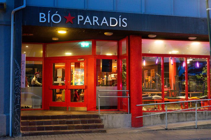 Photograph of the Bio Paradis. There are red window and door frames and fairy lights around the window.