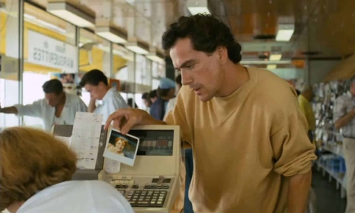 A man is showing someone a photograph of a woman.