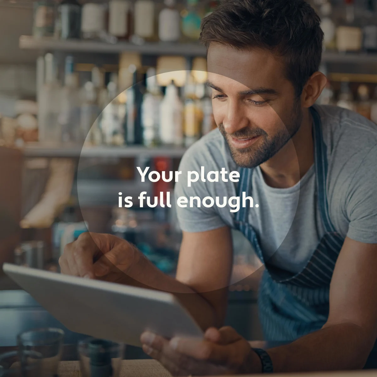 male restaurant manager holding a tablet at the bar