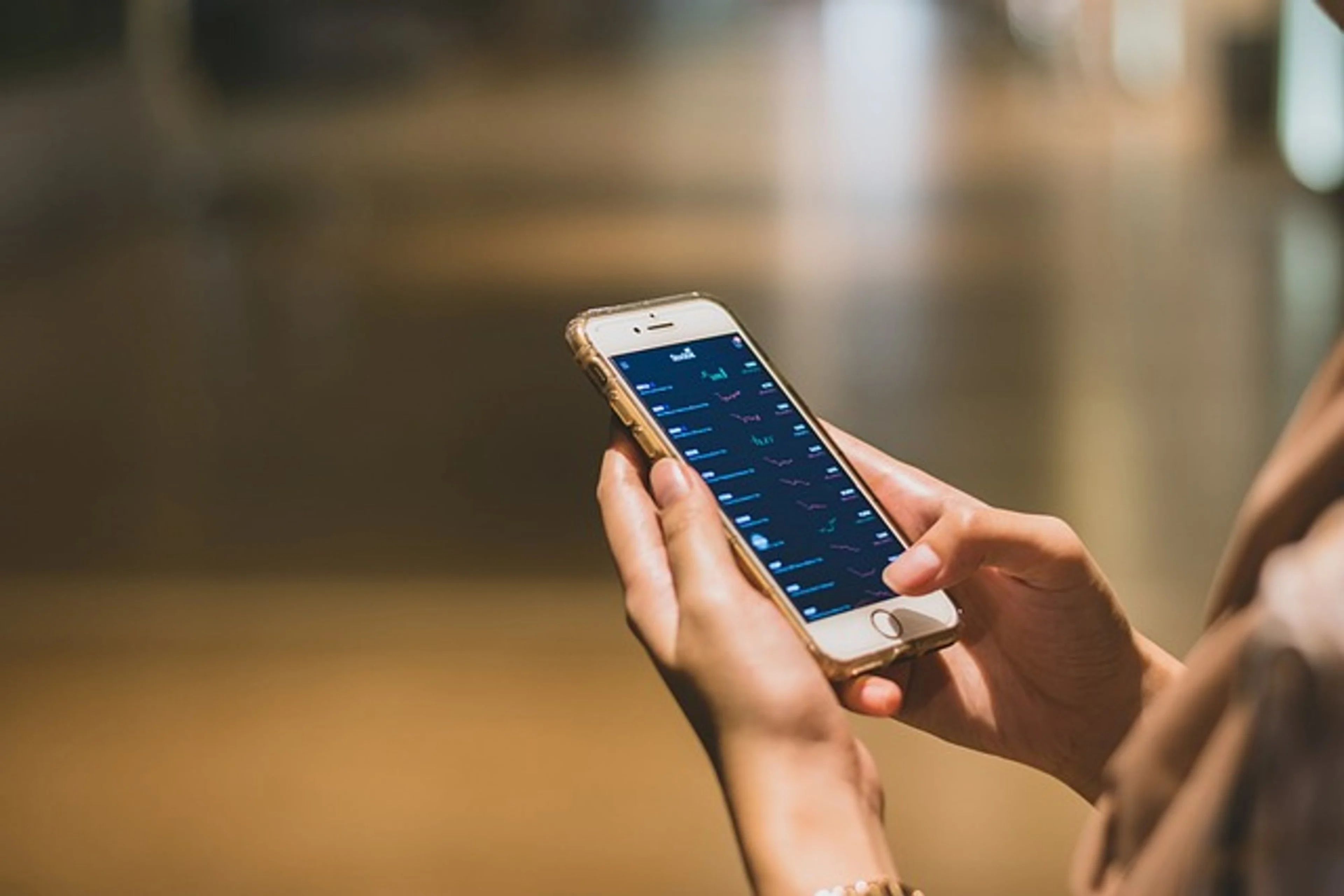 A woman holding a phone viewing an investment app.