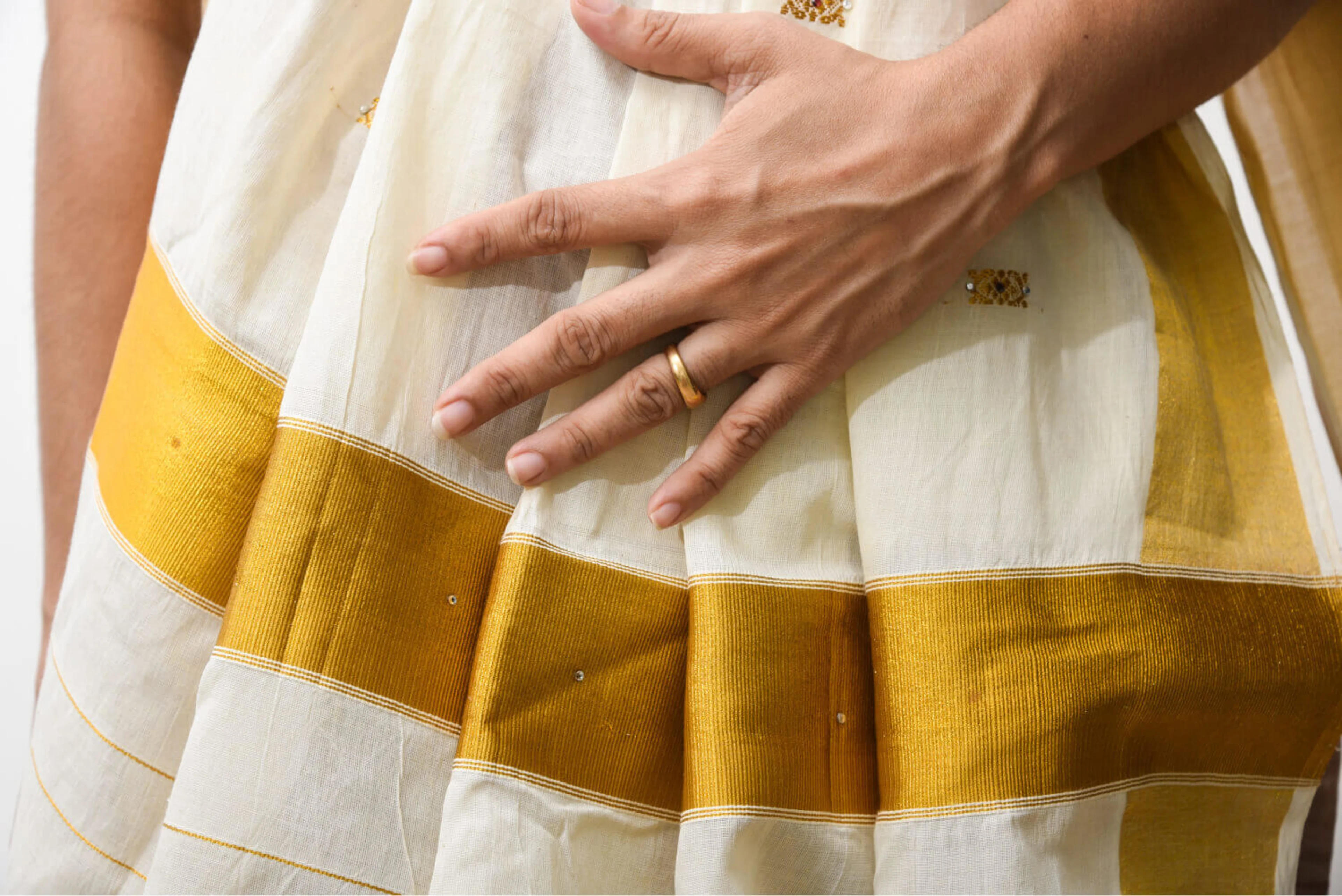 A handmade white and yellow Indian silk sari, worn by a woman