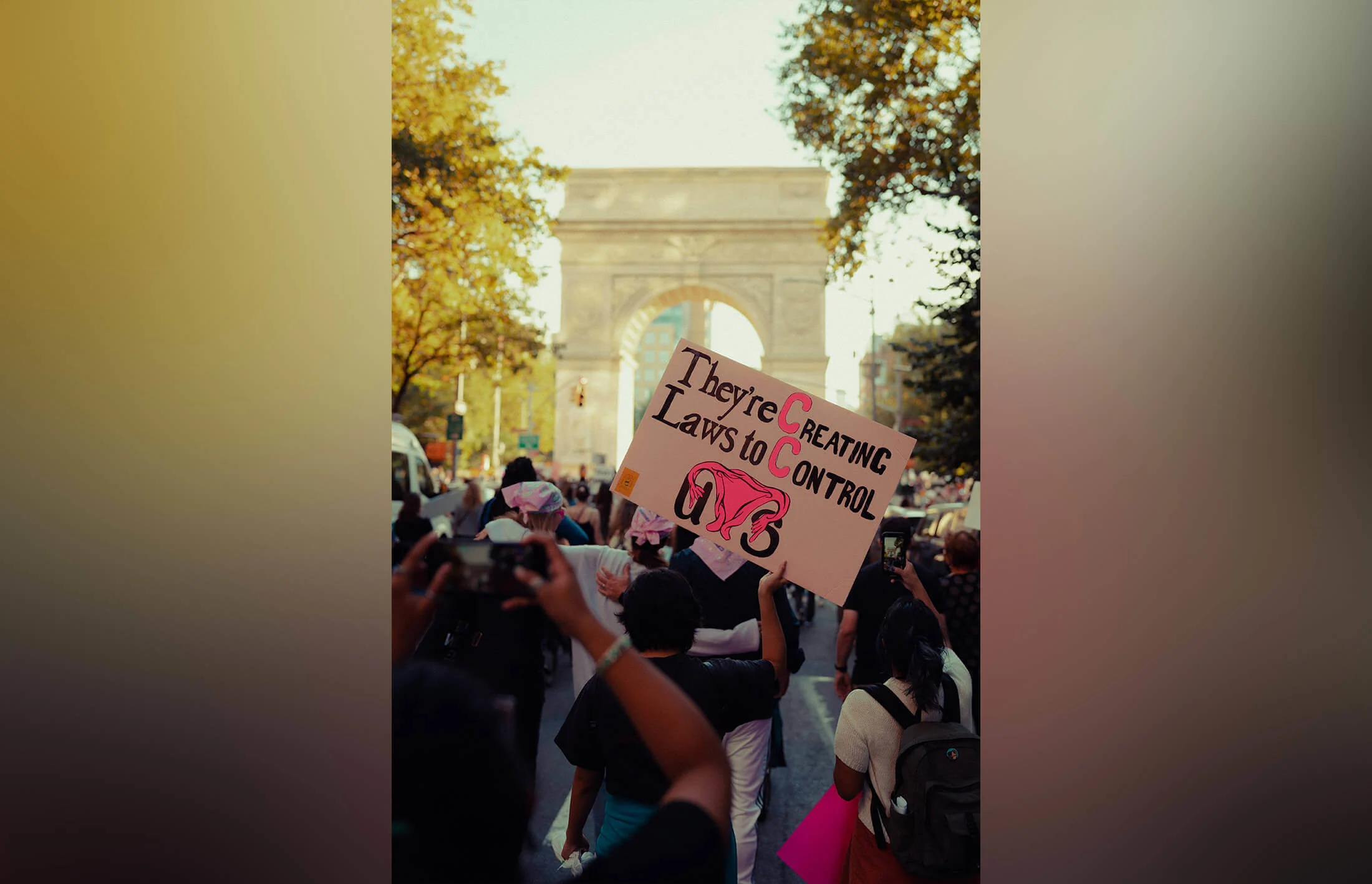 A protester holds up a sign with the message 'They're Creating Laws to Control Us' near the Washington Square Arch, New York.