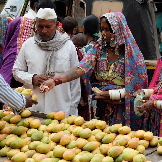 "Women in local ethnic dress buy mangos" stock image