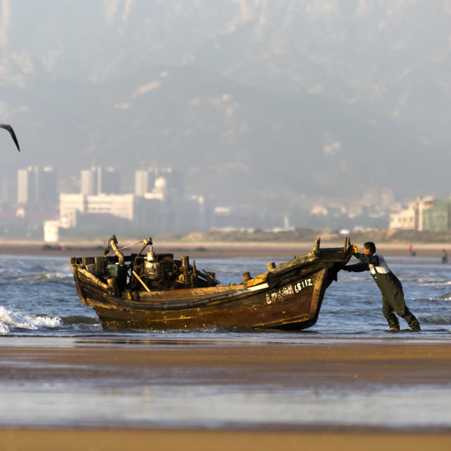 "Back out to Sea - A Fisherman & his Boat in China" stock image