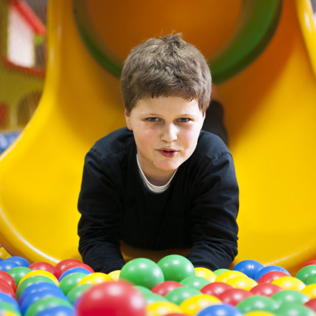 "Boy sliding into ball pool" stock image