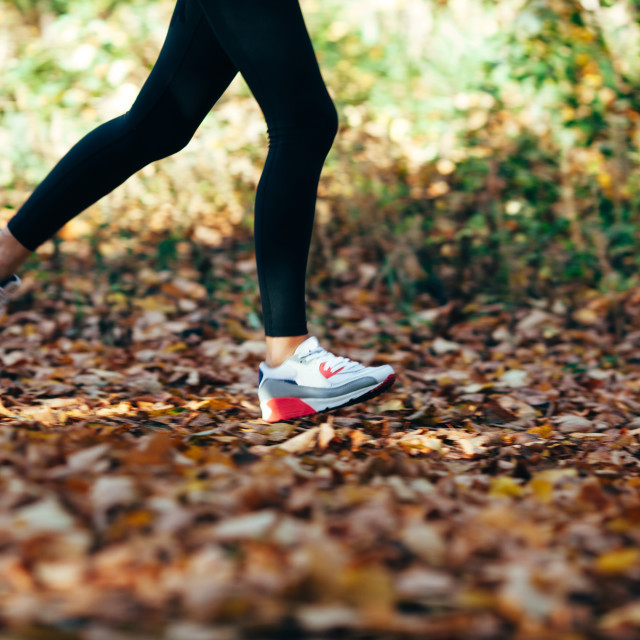 "woman runs for fall foliage, shoes closeup, motion blur" stock image