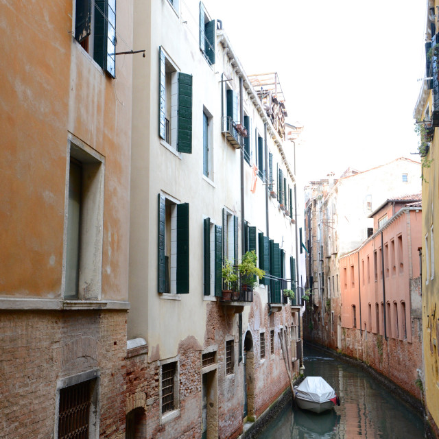 "Covered boat on calm canal in Venice, Italy" stock image