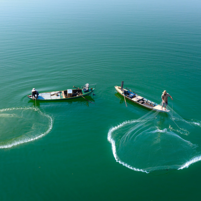 "casting a net to catch fish on Tri An Lake" stock image