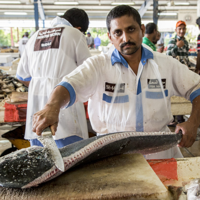 "Man cleaning fish in Dubai's seafood market" stock image