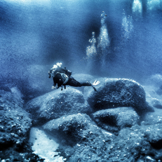 "Young female scuba diver diving deep" stock image