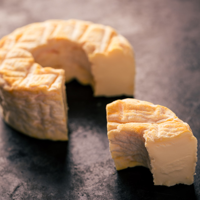 "Portion cut from whole camembert cheese with orange color" stock image