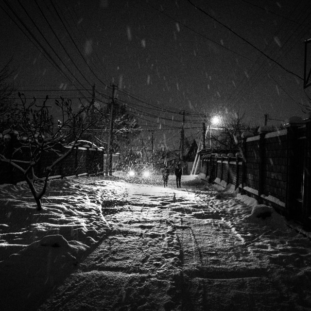 "Car headlights and two figures in a blizzard, Bishkek Kyrgyzstan." stock image