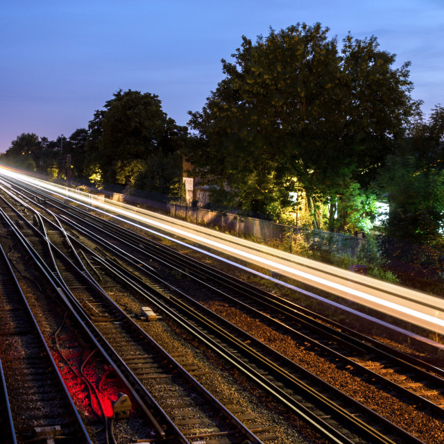 "A trace of light is left by a passing commuter train at dusk in south London, UK." stock image