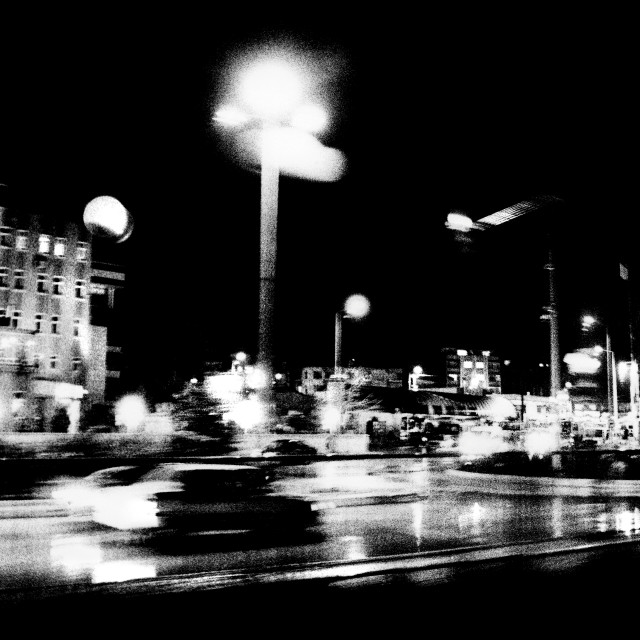 "Grainy and murky view of a car speeding through a street at night" stock image