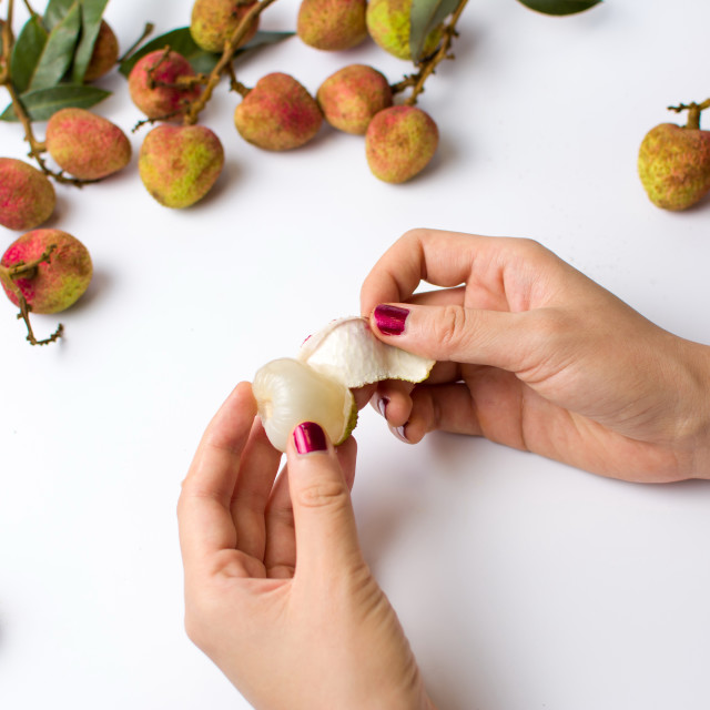 "Female hands peeling lychee fruit" stock image