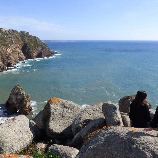 "People at cliff side contemplate nature and sea" stock image