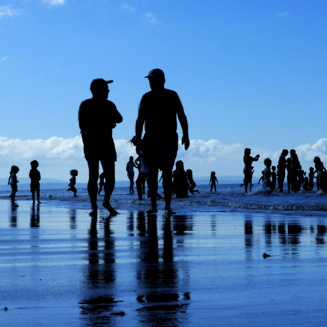 "Silhouettes of people on a summer morning on the beach" stock image