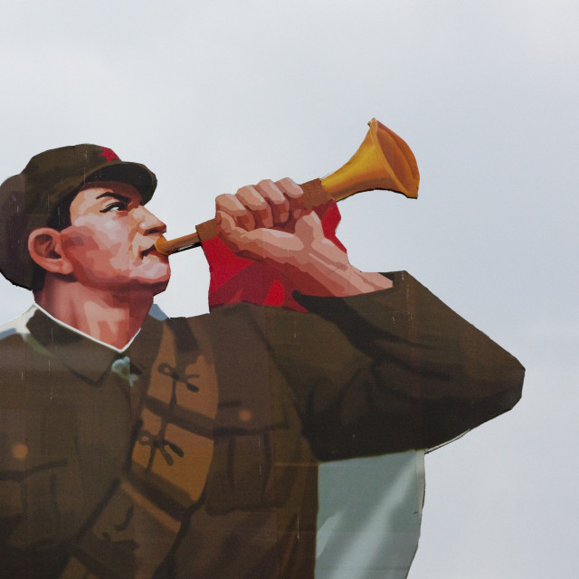 "Painted billboard of a North Korean soldier blowing in a horn on Kim il Sung..." stock image