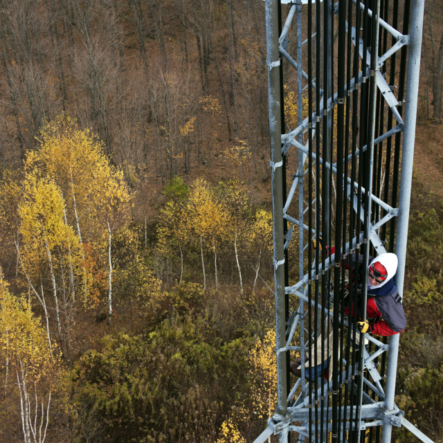 "Climber on cell tower" stock image