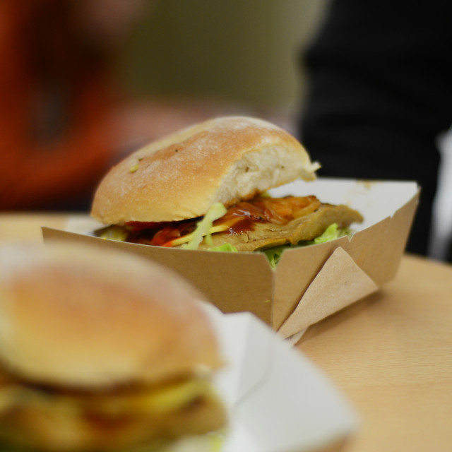 "A burger in cardboard box at a food festival" stock image