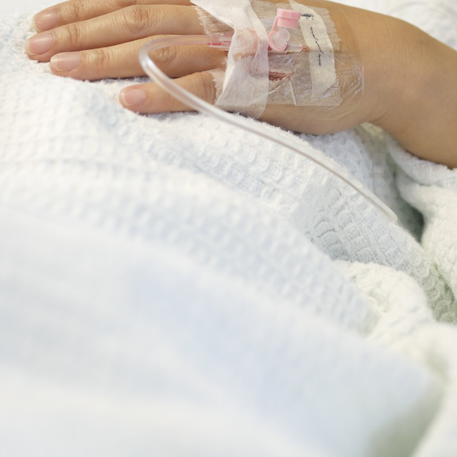 "Hand of hospitalized patient inserted with iv drip" stock image