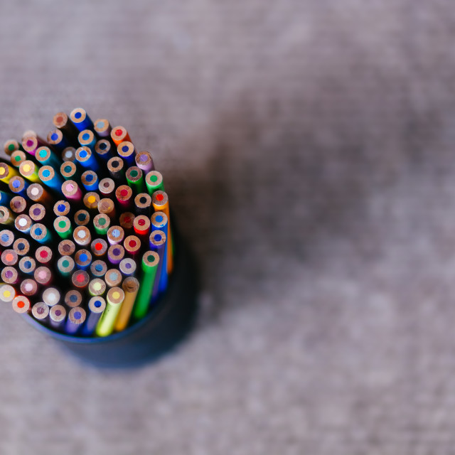 "Pencil Holder Holding a Variety of Colored Pencils on a Grey Textured Background" stock image