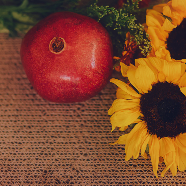 "Sunflowers and Pomegranate Arrangement on a Brown, Textured Background" stock image