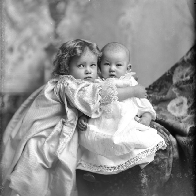 "VINTAGE PHOTO OF CHILD HUGGING A BABY" by JOHN MOUNT - $25.10 "VINTAGE PHOTO OF CHILD HUGGING A BABY" stock image